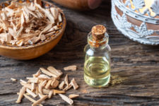 a bottle of cedar essential oil with cedar wood