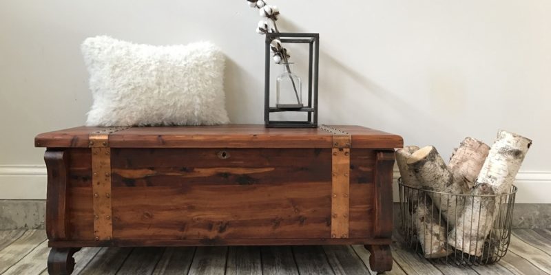 stylish cedar chest used creatively in a living room with a pillow and decor on its lid